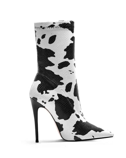 Bottines femme à talons aiguilles avec imprimé vache blanc. Fermeture éclair latérale, bout pointu. Disponibles en grandes tailles.